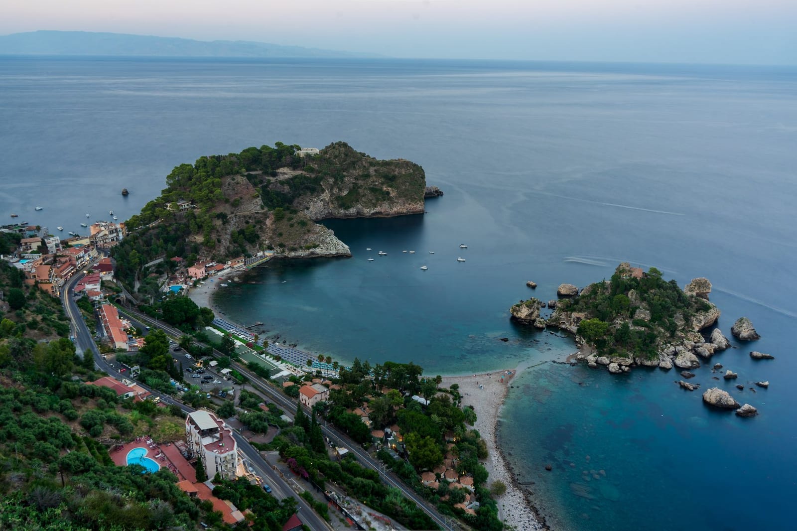 Isola Bella and its tidal causeway curving below Taormina