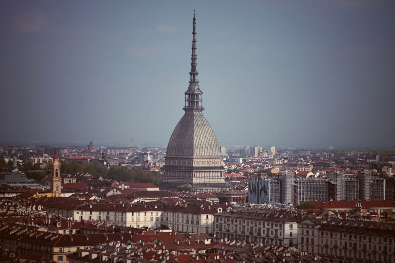 The Mole Antonelliana rising over Turin's rooftops toward the Alps