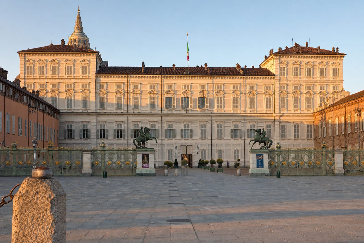 The Royal Palace of Turin behind its gilded gates at dusk