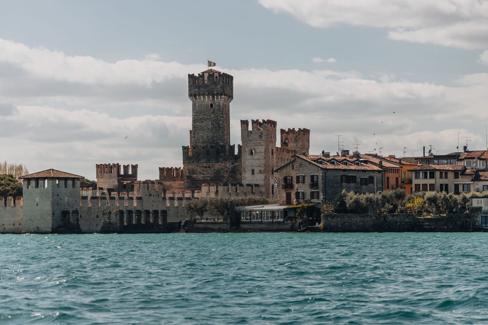 The Scaliger castle of Sirmione rising from Lake Garda beside its harbor