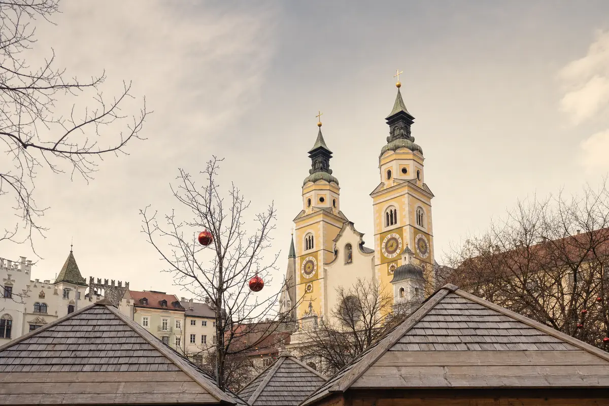 Wooden market roofs beneath the twin towers of Bressanone Cathedral