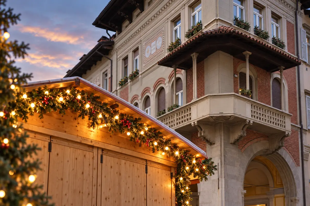 A wooden Christmas stall beneath the covered corner balcony on Via Roma in Rovereto
