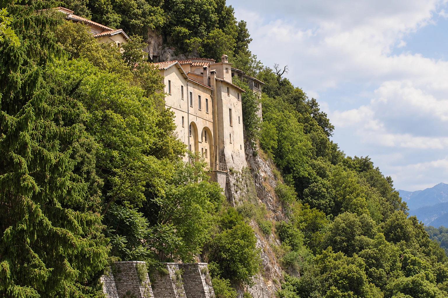 The convent of Greccio against its wooded limestone cliff