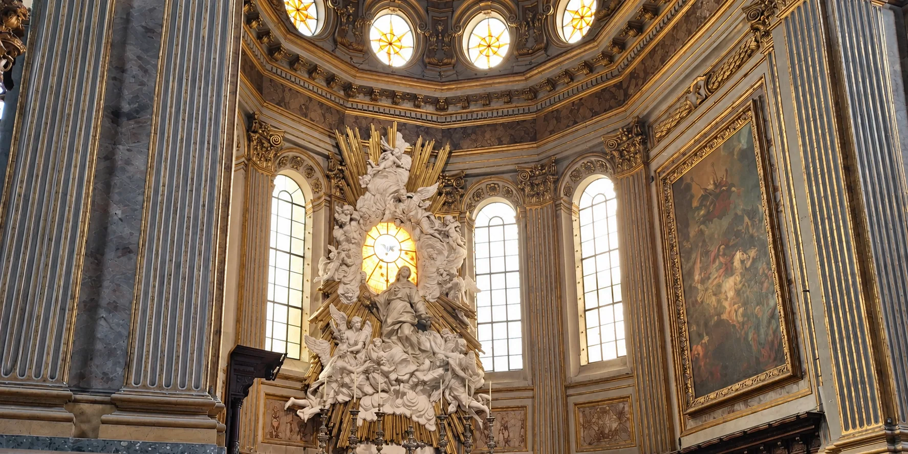 Oval star-patterned windows and lower arched windows frame a broad sculptural group between fluted marble piers.