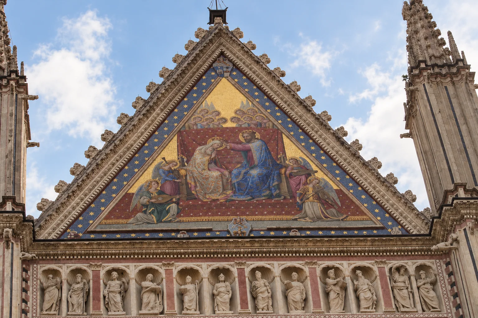 Triangular gold-background mosaic with blue star-patterned border, carved stone edges and a partial statue row beneath.