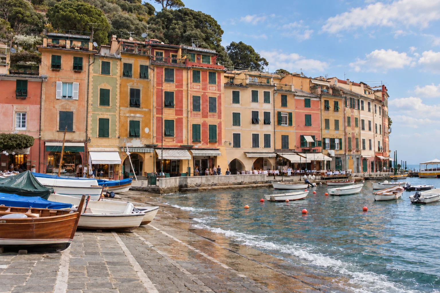 Painted waterfront facades and small moored boats in Portofino’s harbor. / Facciate dipinte e piccole barche ormeggiate nel porto di Portofino.