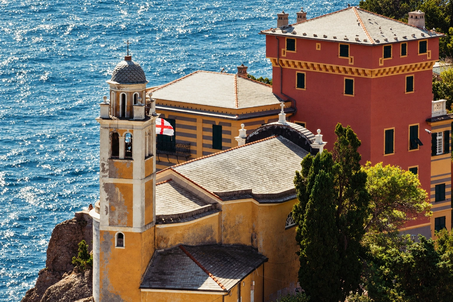 San Giorgio sopra il mare: Il campanile di San Giorgio si alza tra i tetti in ardesia del promontorio di Portofino, con il mare sullo sfondo.