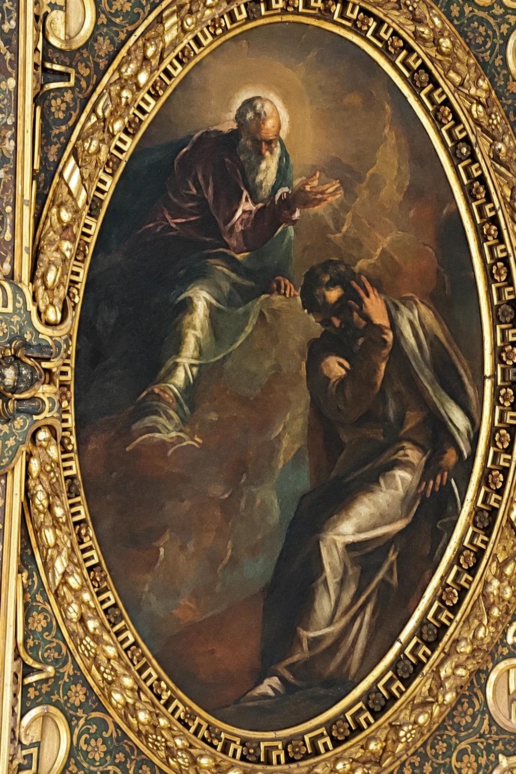 Painted figures within a tall gilded oval surround at Scuola Grande di San Rocco.