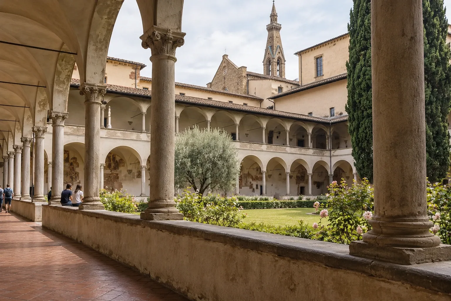 The great cloister of Santa Croce with a long stone arcade, lawn and rose bushes, two visitors sitting on the low wall