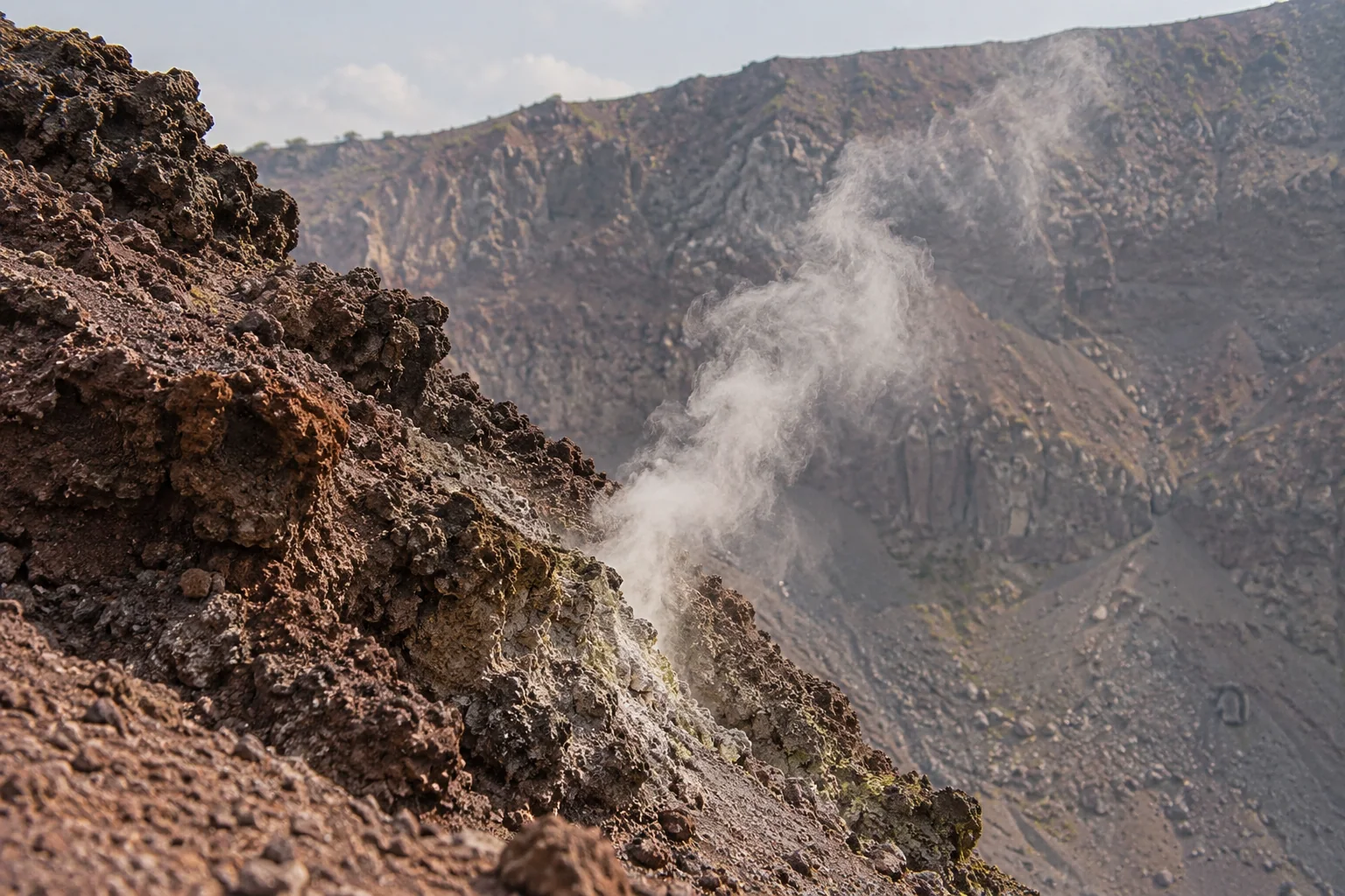 A wisp of steam rising from a vent in the crater wall of Vesuvius