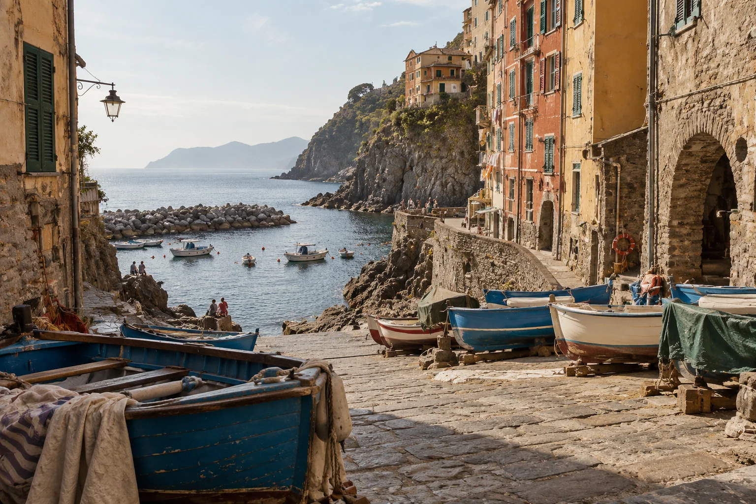Blue fishing boats hauled up between houses at Riomaggiore's Marina Piccola