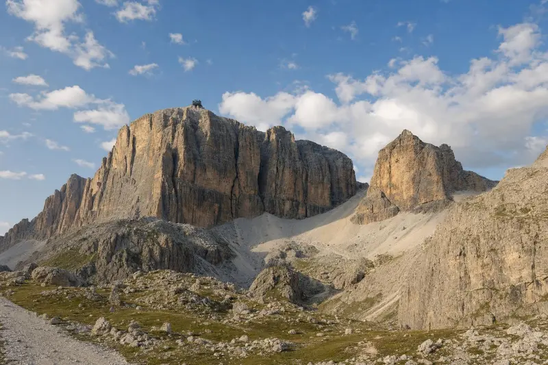 The layered cliffs of Sass Pordoi above pale scree slopes