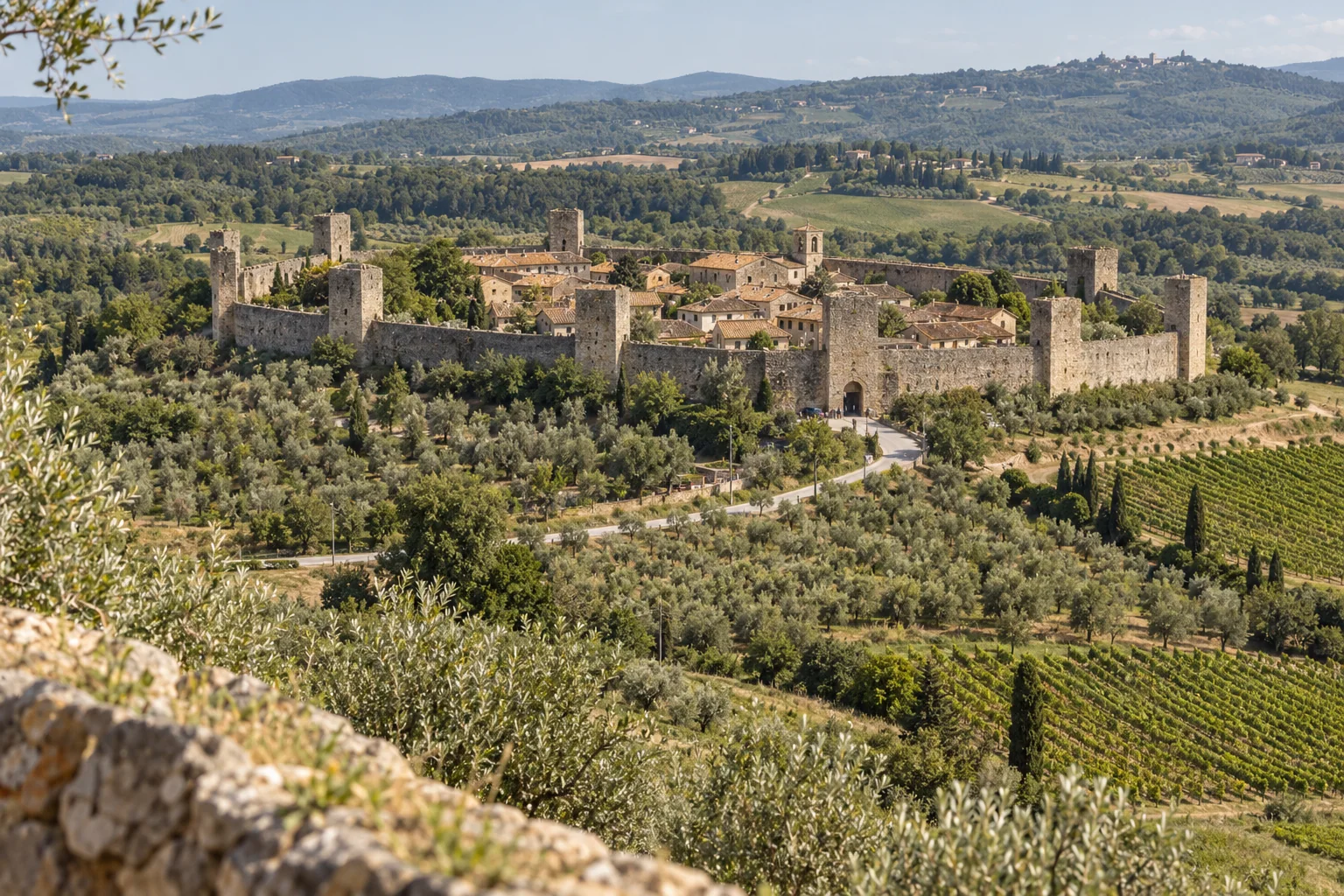 Monteriggioni from above, a ring of walls and towers around a small village among olive groves