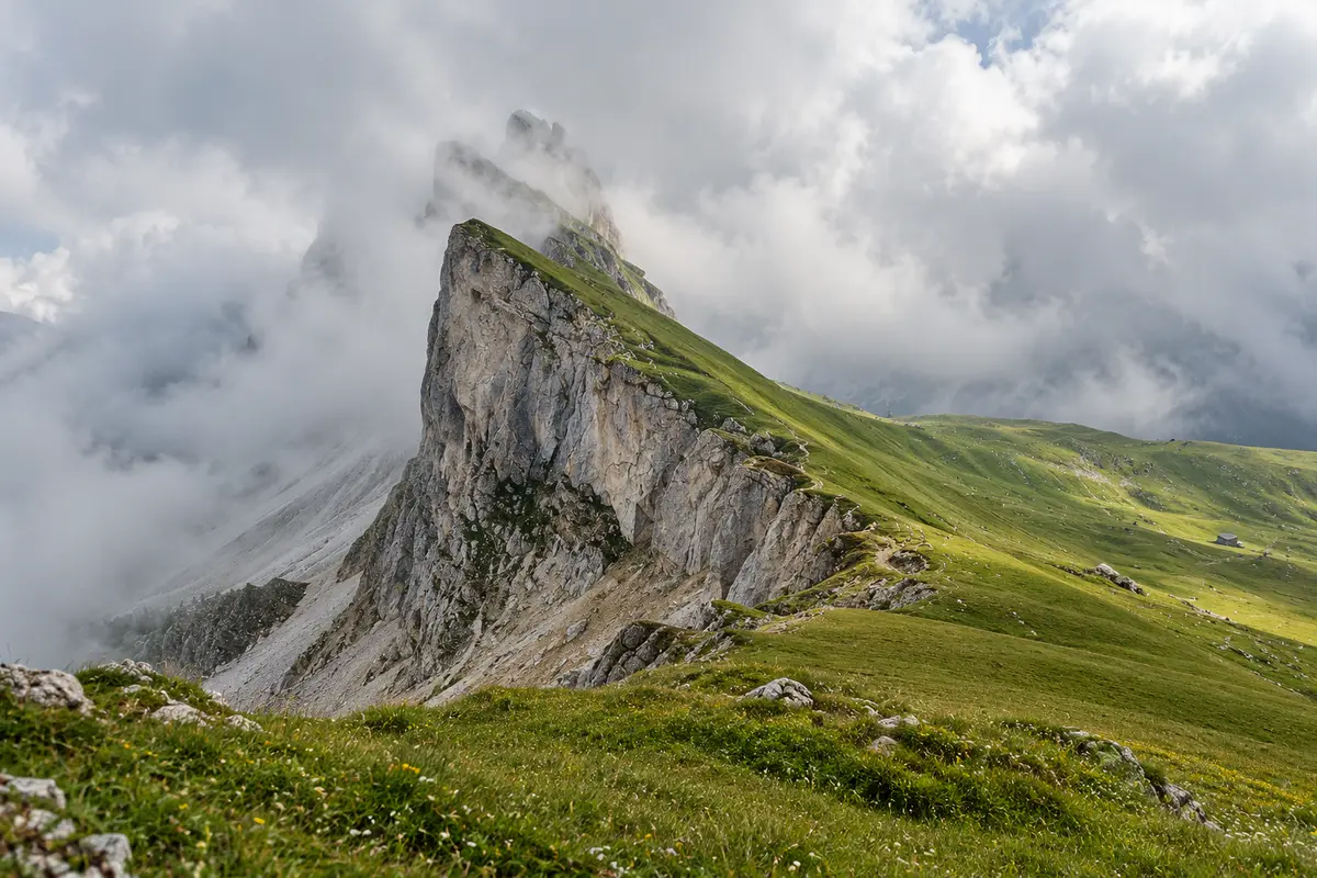 Low cloud around the grassy Seceda ridge and its limestone cliffs in the Dolomites
